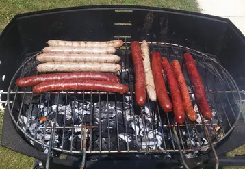 saucisses de chipolatas en cuisson sur barbecue