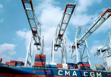 bateau porte conteneur au port devant des grues