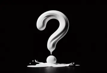 un point d'interrogation fait de lait renversé sur fond noir