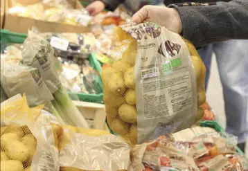 main attrapant un sac de pomme de terre en magasin