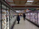 clients devant les vitrines réfrigérées d'un supermarché