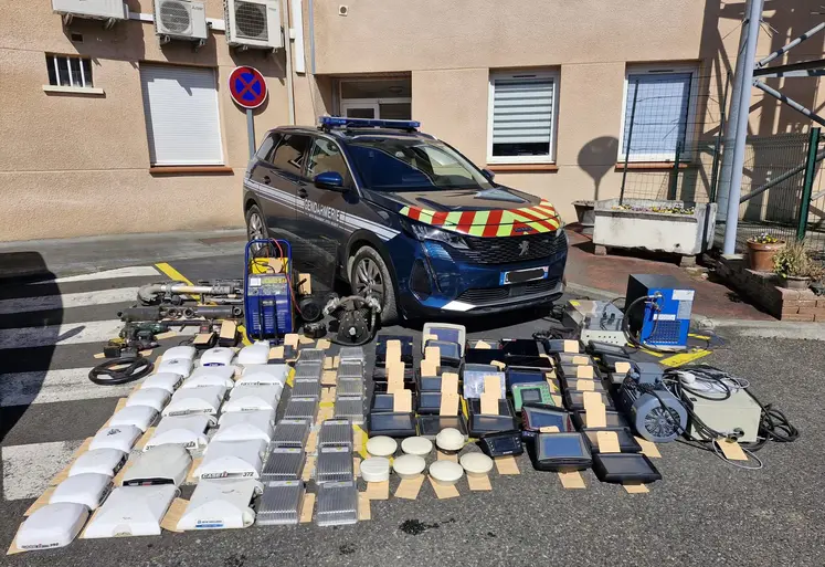 GPS agricoles récupérés auprès de voleurs étalés devant une voiture de la gendarmerie nationale.