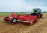 <em class="placeholder">cultivateur Güttler Feldmeister LK 60 en action derrière un tracteur Claas.</em>