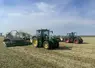 Andaineur à tapis Krone Swativo T 1040 Pro derrière un tracteur John Deere