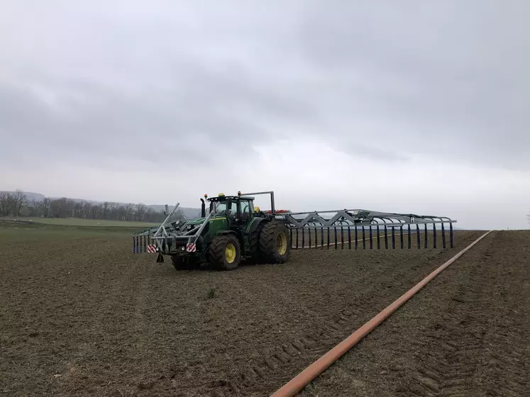 Chantier d'épandage de digestat sans tonne Listech avec tracteur John Deere à roues jumelées et rampe à pendillard