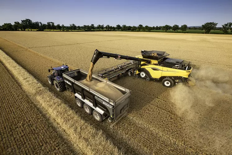 Moissonneuse-batteuse New Holland CR 11 à la vidange de sa trémie dans une benne monocoque Maitre tirée par un tracteur New Holland