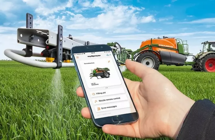 Vue d'un smartphone avec l'application My Sprayer d'Amazone et pulvérisateur Amazone UX attelé à un tracteur Fendt