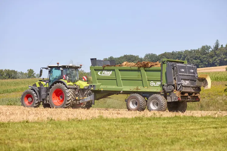 <em class="placeholder">Epandeur à fumier Fliegl KDS 255 Muck Control derrière un tracteur Claas en action.</em>
