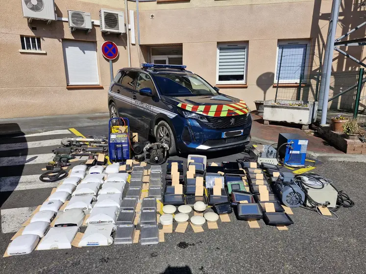 GPS agricoles récupérés auprès de voleurs étalés devant une voiture de la gendarmerie nationale.
