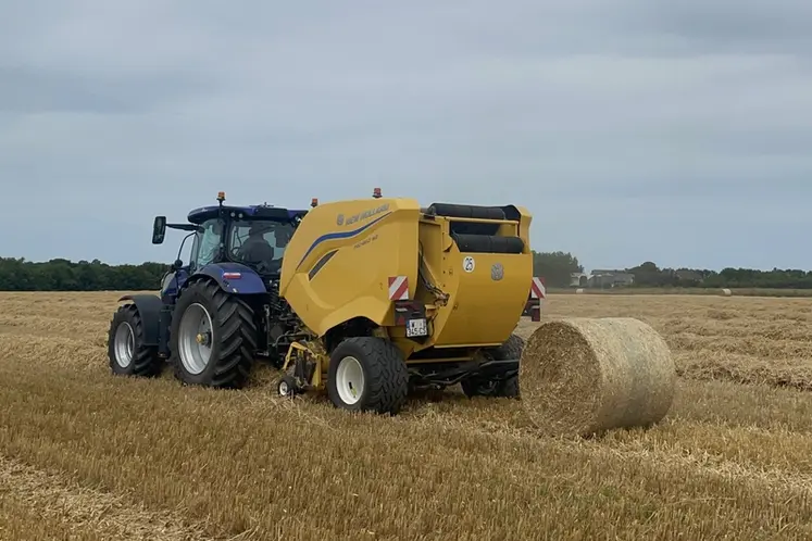 <em class="placeholder">Presse à balles rondes à chambre variable New Holland Pro-Belt 165 au travail dans la paille d&#039;orge</em>