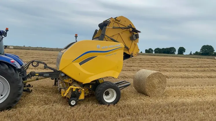 <em class="placeholder">Presse à balles rondes à chambre variable New Holland Pro-Belt 165 au travail dans la paille avec tracteur New Holland T7.210 AutoCommand</em>