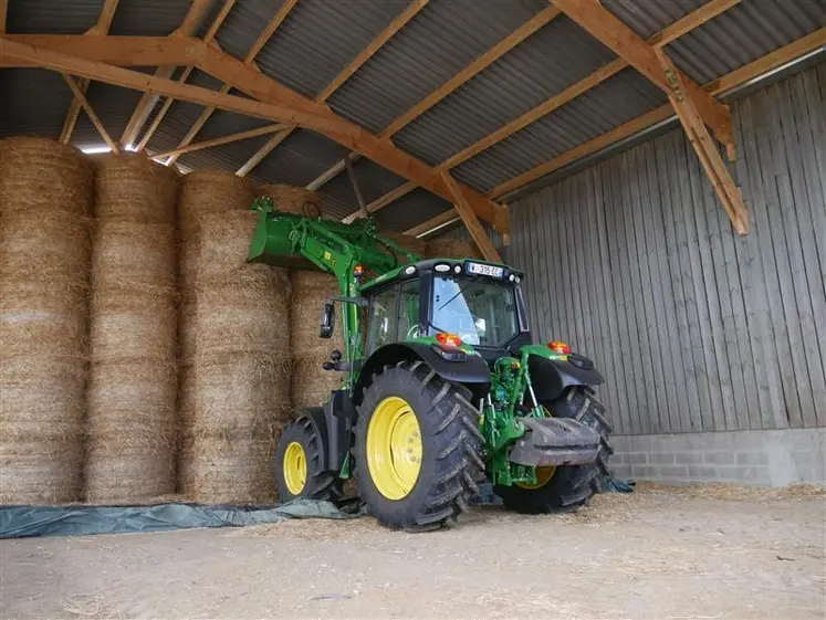 <em class="placeholder">Tracteur John Deere avec chargeur devant un stockage de balles de paille rondes.</em>