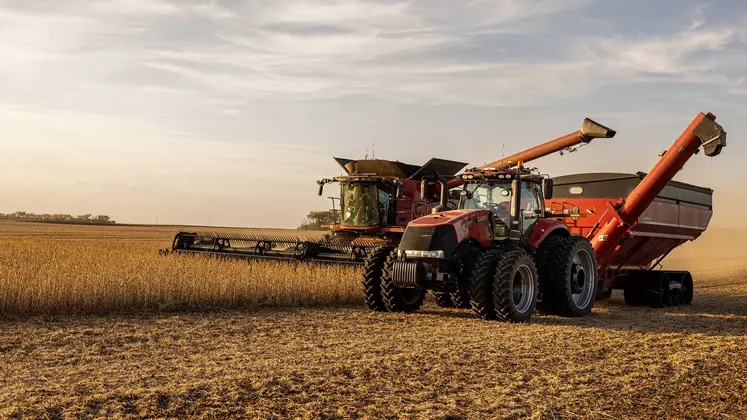 Moissonneuse-batteuse Case IH et tracteur Case IH attelé à un transbordeur.