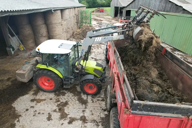 <em class="placeholder">Vue du tracteur Claas Axos 3.105 en train de charger une benne de fumier</em>