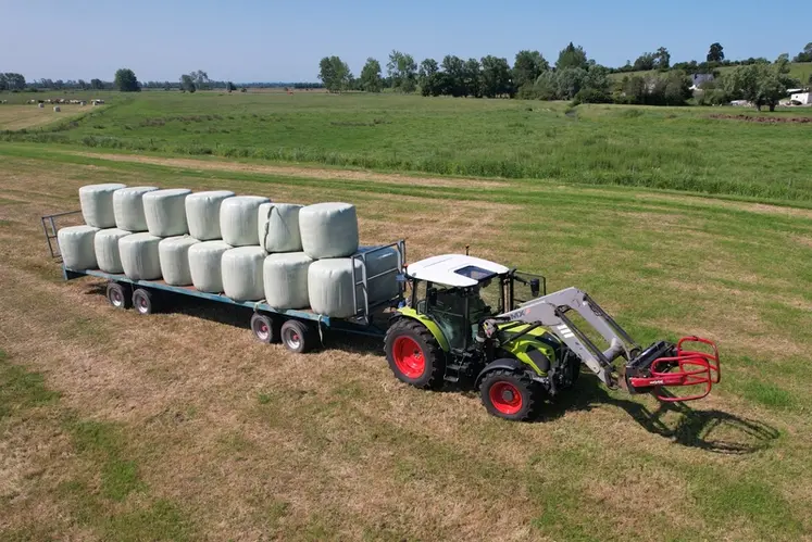 <em class="placeholder">Tracteur Claas Axos 3.105 avec chargeur frontal MX et plateau fourrager Lenormand à essieux chargé de balles d'enrubannage.</em>