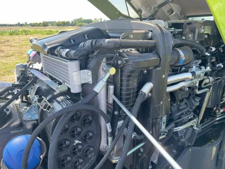 <em class="placeholder">Vue du moteur du tracteur Claas Axos 3.105 avec le capot levé et la soufflette pour nettoyer les radiateurs</em>