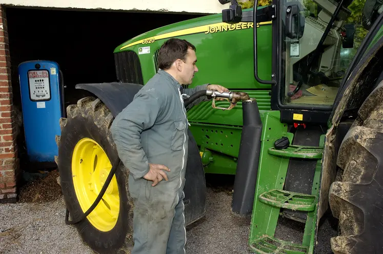 Agriculteur qui fait le plein de son réservoir de tracteur avec du Gazole non routier (GNR).
