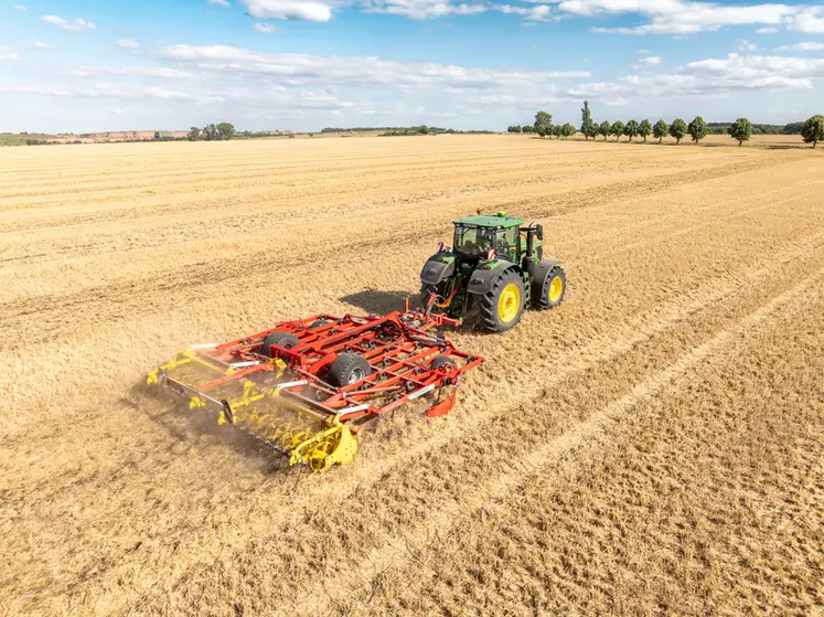 <em class="placeholder">Déchaumeur à dents scalpeur Plano VT 6060 de Pöttinger derrière un tracteur John Deere. </em>