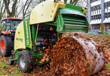 Presse à balle ronde Krone récoltant des feuilles mortes sur la voirie allemande.