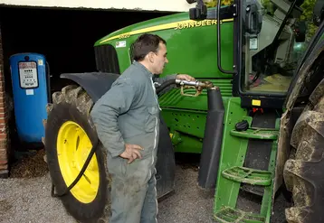 Agriculteur qui fait le plein de son réservoir de tracteur avec du Gazole non routier (GNR).