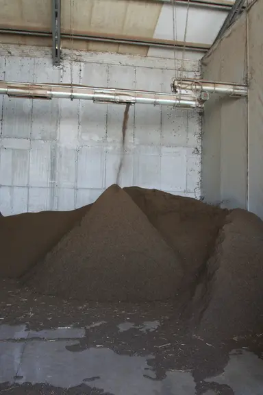 Une fois séchée, la fraction solide quitte le séchoir par une vis sans fin pour constituer un tas sur une surface bétonnée située sous un hangar, avan