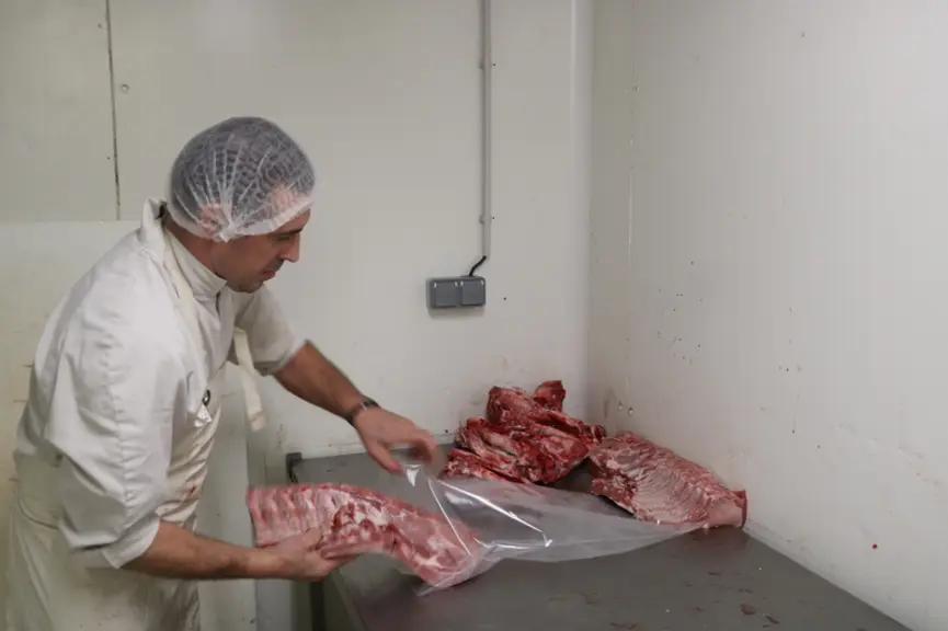 Un boucher travaille à plein temps au laboratoire de transformation sur la ferme.