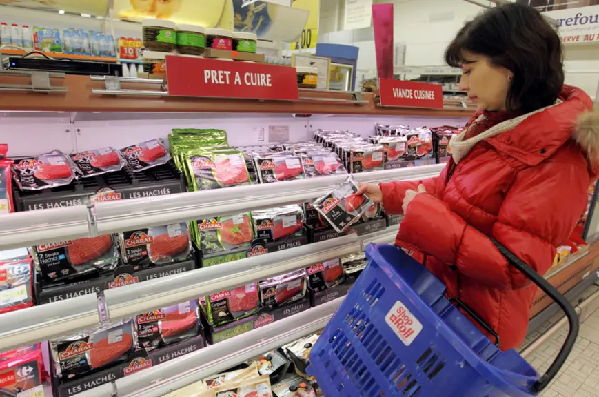 Cliente en grande distribution achetant des pavés de boeuf au rayon viande d'un supermarché. Magasin Carrefour. Produit alimentaire issu de la product