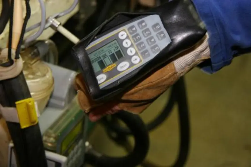 Equipé d’un gant avec un Commander, le trayeur bipe la boucle électronique de pâturon puis celle située sur les tuyaux reliant la griffe où la chèvre