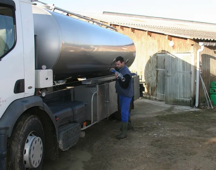 Camion de collecte du lait dans une cour de ferme