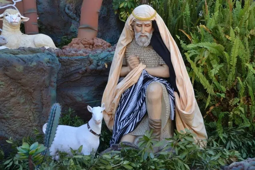 Statue d'un homme avec une chèvre dans un jardin. Figurines de crèche de Noël.