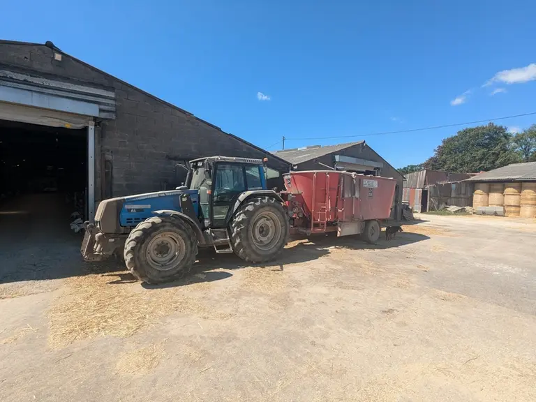 Tracteur attelé à une mélangeuse