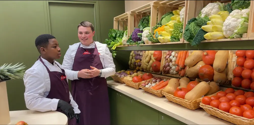 Wassim (Wasko'Fruits) avec un apprenti devant l'étal de légumes du Cifca à Paris.