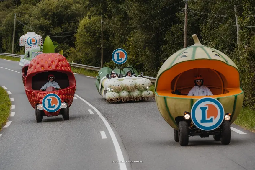 des véhicules en forme de fruits et légumes géants : melon, fraise, poireau et caché derrière la cerise