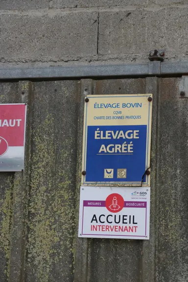 Le panneau d’accueil intervenants, apposé sur la porte de la laiterie, à l'entrée de la zone d'élevage.