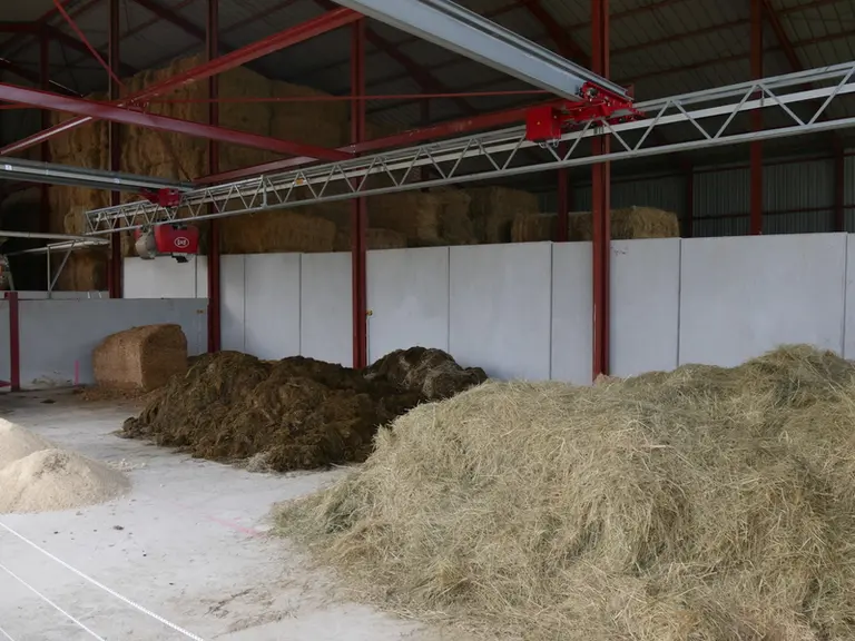 Utilisant un grappin pour le chargement du bol mélangeur autonome Vector, la cuisine Lely se contente d'une dalle bétonnée pour le stockage des fourra