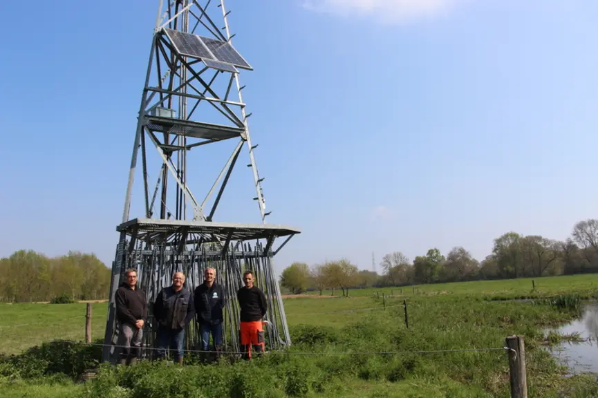 Groupe d'éleveurs devant une éolienne de pompage
