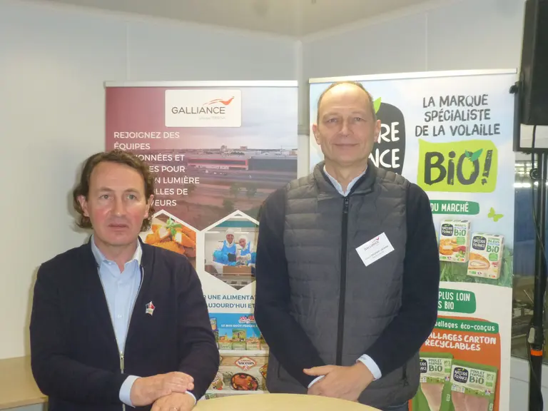 Deux hommes devant des affiches publicitaires