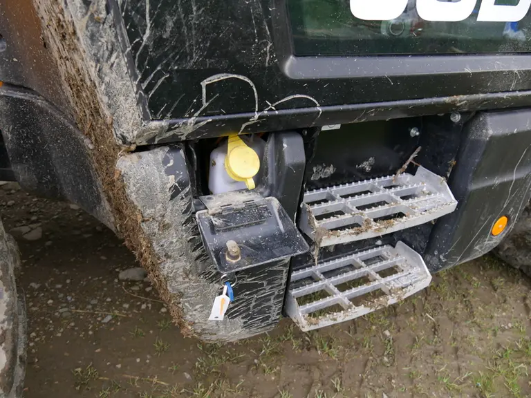 Sur le chargeur télescopique JCB Série III, la réserve de lave-glace est cachée derrière une trappe fermant à clé et située à gauche du marchepied.  ©
