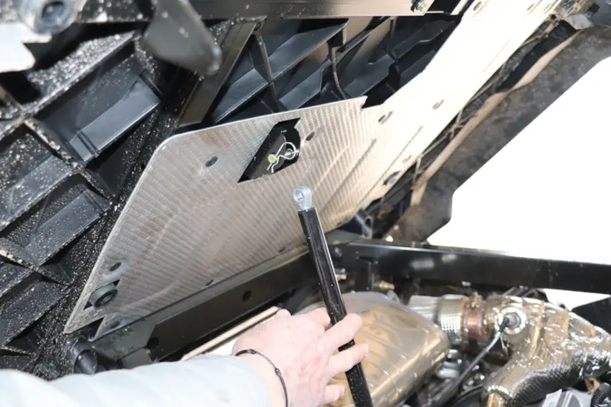 Le vérin d'accompagnement de la benne se détache pour dégager un meilleur accès au moteur Rotax du Can-Am Traxter HD10 Pro  © D. Laisney