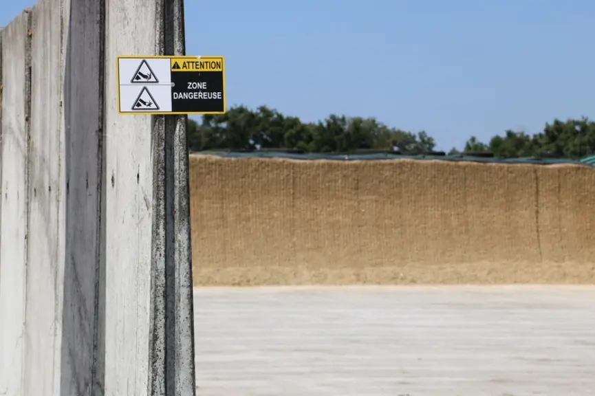 Des panneaux de sécurité sont apposés à chaque entrée de silo où la mélangeuse automotrice Kuhn Aura vient charger l'ensilage.