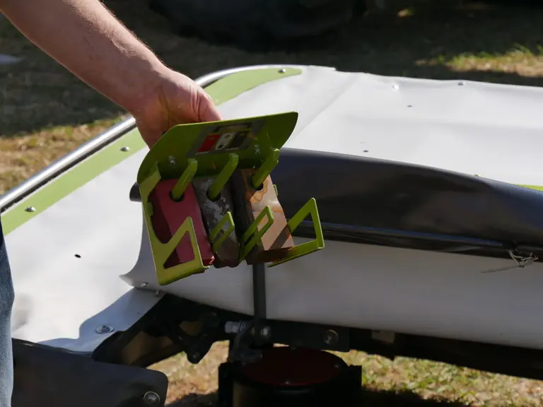 La boîte à couteaux de la faucheuse portée Claas Disco 4400 dispose d'un rangement pour les modèles usagés.