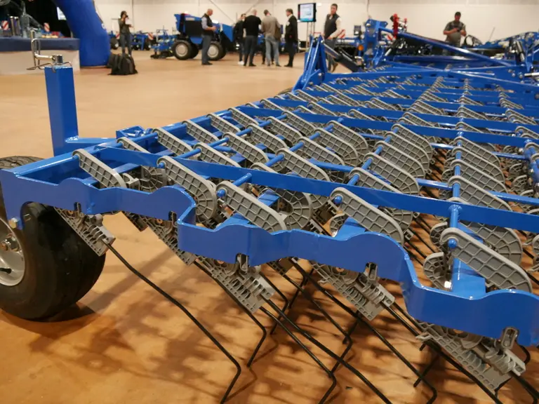 La herse étrille Pressius de Carré utilise des pièces en matière composite fibrée pour ajuster la pression au sol des peignes.