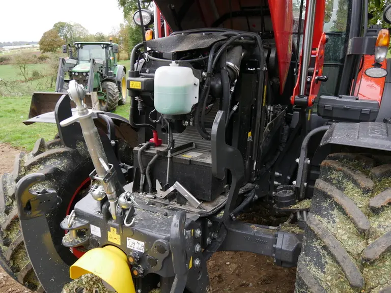 Le vase d'expansion du liquide de refroidissement est bien visible à l'avant du compartiment moteur du Kubota M6.