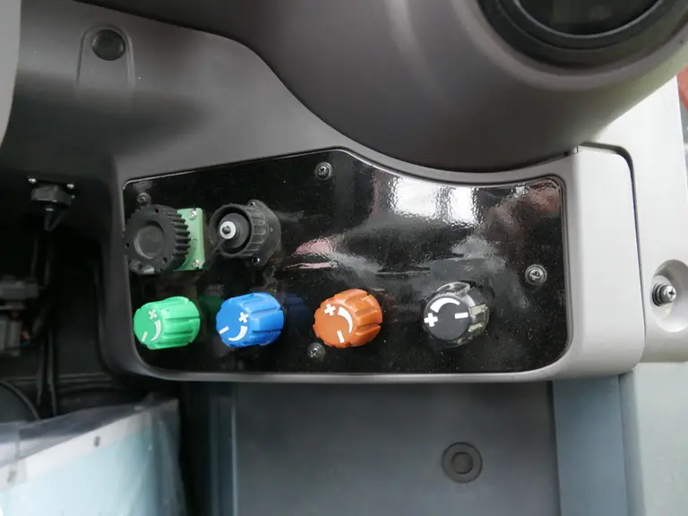 Le débit des distributeurs hydrauliques du Kubota M6 se règle manuellement à l'aide de molettes à l'arrière du siège.