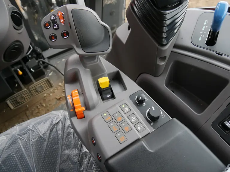 L'accoudoir multifonction du Kubota M6 intègre l’accélérateur à main, les boutons pour engager la prise de force, le pont-avant et le blocage du diffé