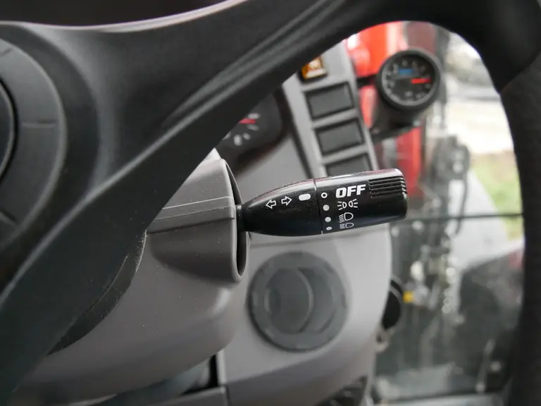 Le comodo de clignotants et de feux de route s'actionne avec la main droite sur le tracteur Kubota M6.