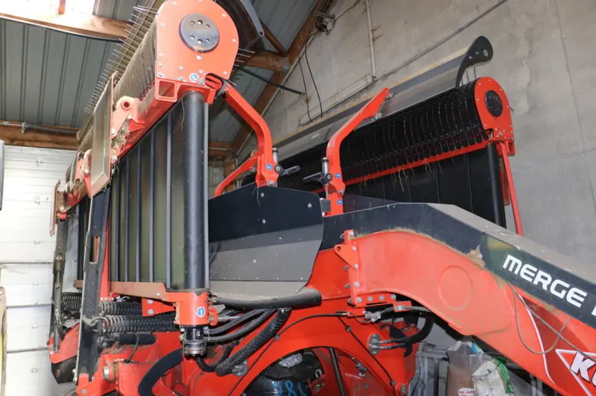 L'andaineur à tapis Kuhn Merge Maxx 950 dispose au-dessus du pick-up d'un rouleau et d'une tôle de guidage qui régularisent le flux d'herbe arrivant s