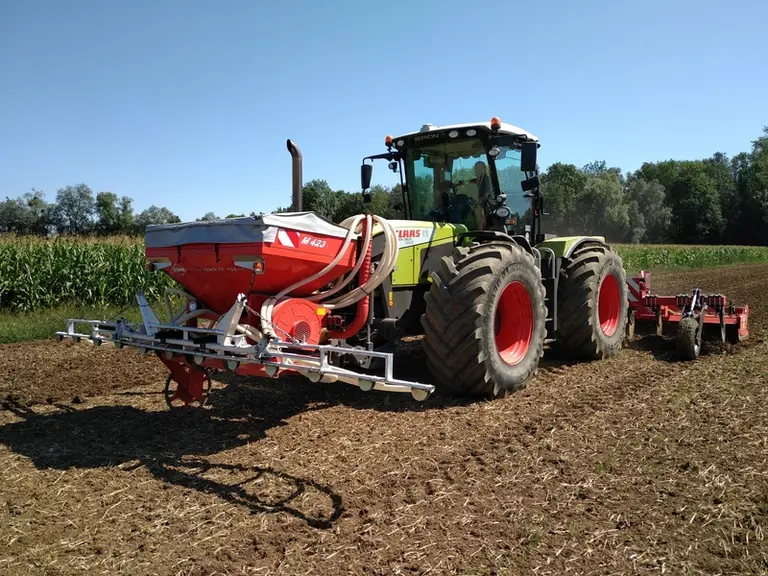 Un distributeur à rampe sème à la volée la féverole et le fenugrec qui sont ensuite enfouis en surface par la combinaison décompacteur-herse rotative.