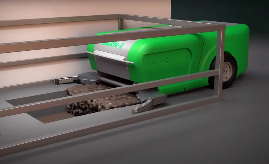 Robot racleur Barn-E arrivant à sa station de recharge