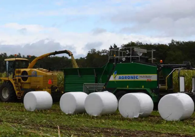 Presse enrubanneuse Knoll Multibaler XL accrochée derrière une ensileuse FX New Holland